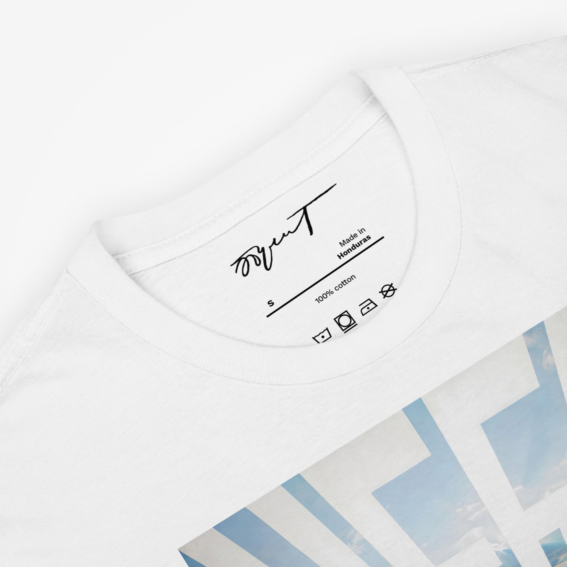 Close-up of Erik Bulatov's Sky and Sea artwork on a white T-shirt, highlighting the detailed sky and sea interplay
