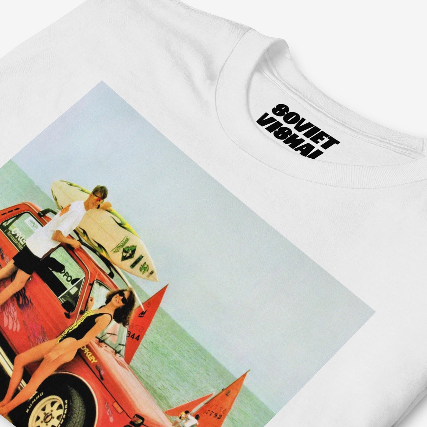 Detailed print of a Lada Niva off-road car with surfers by the shore, on a high-quality T-shirt with branded inside label