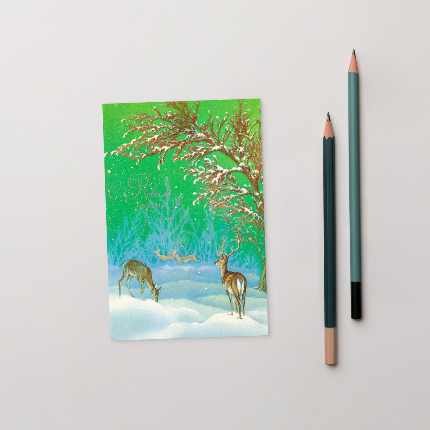 original vintage Soviet New Year postcard with deers in a snowy forest - on the table with pencils