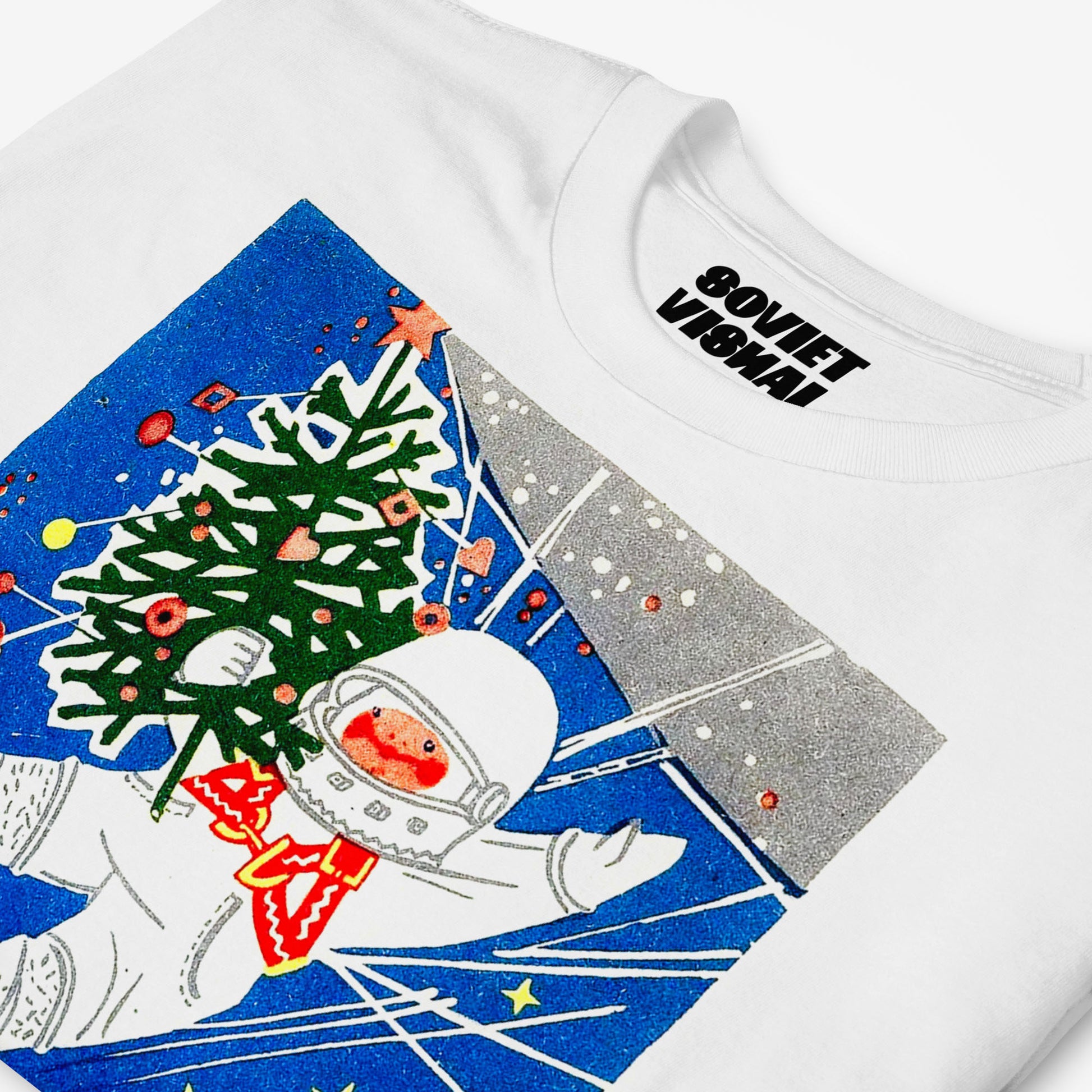 white unisex t-shirt with a young cosmonaut kid in space holding a christmas tree - closeup photo