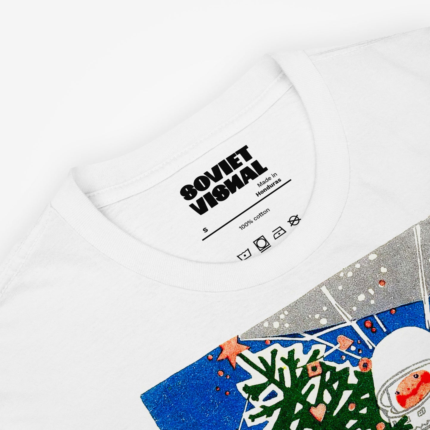 white unisex t-shirt with a young cosmonaut kid in space holding a christmas tree - closeup photo with inside lable and 'Soviet Visual' logo 