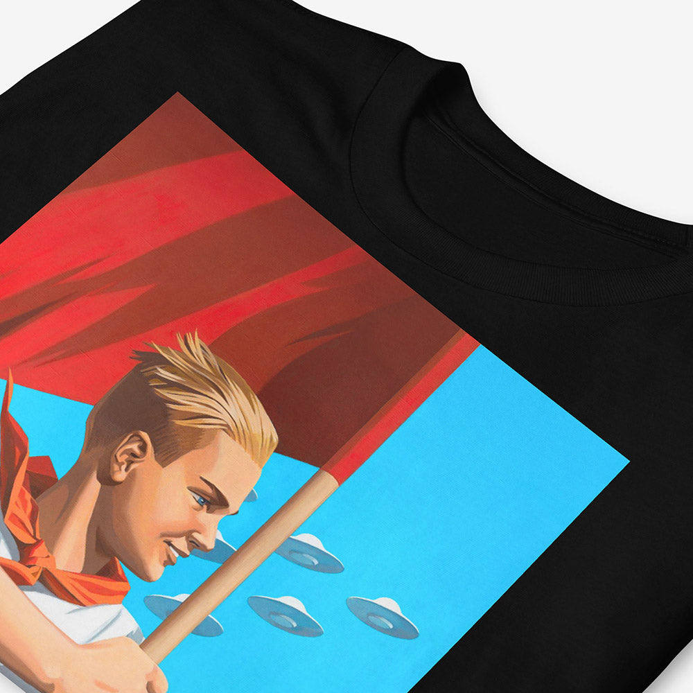 T-shirt with artwork of beautiful blonde Soviet pioneer boy holding red flag with UFO flying in blue sky behind him, space-age patriotic design
