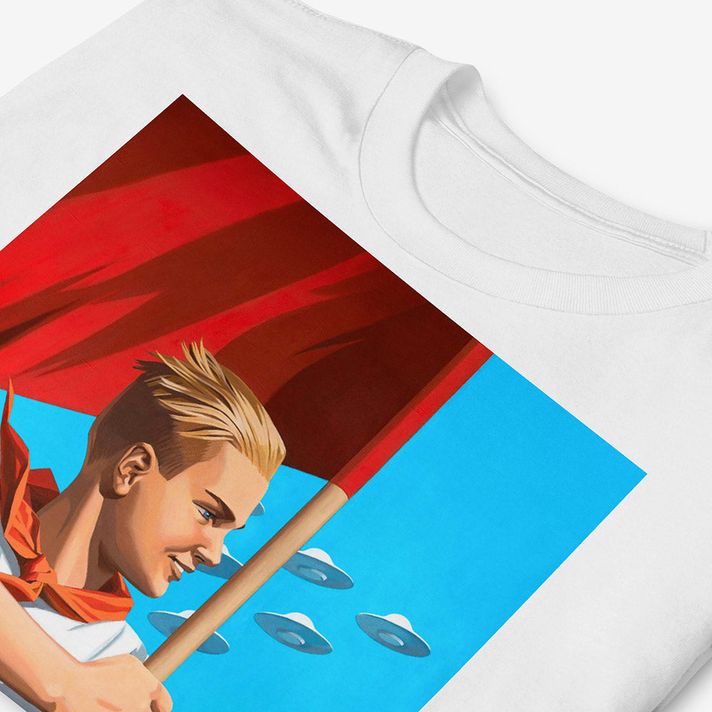 T-shirt with artwork of beautiful blonde Soviet pioneer boy holding red flag with UFO flying in blue sky behind him, space-age patriotic design