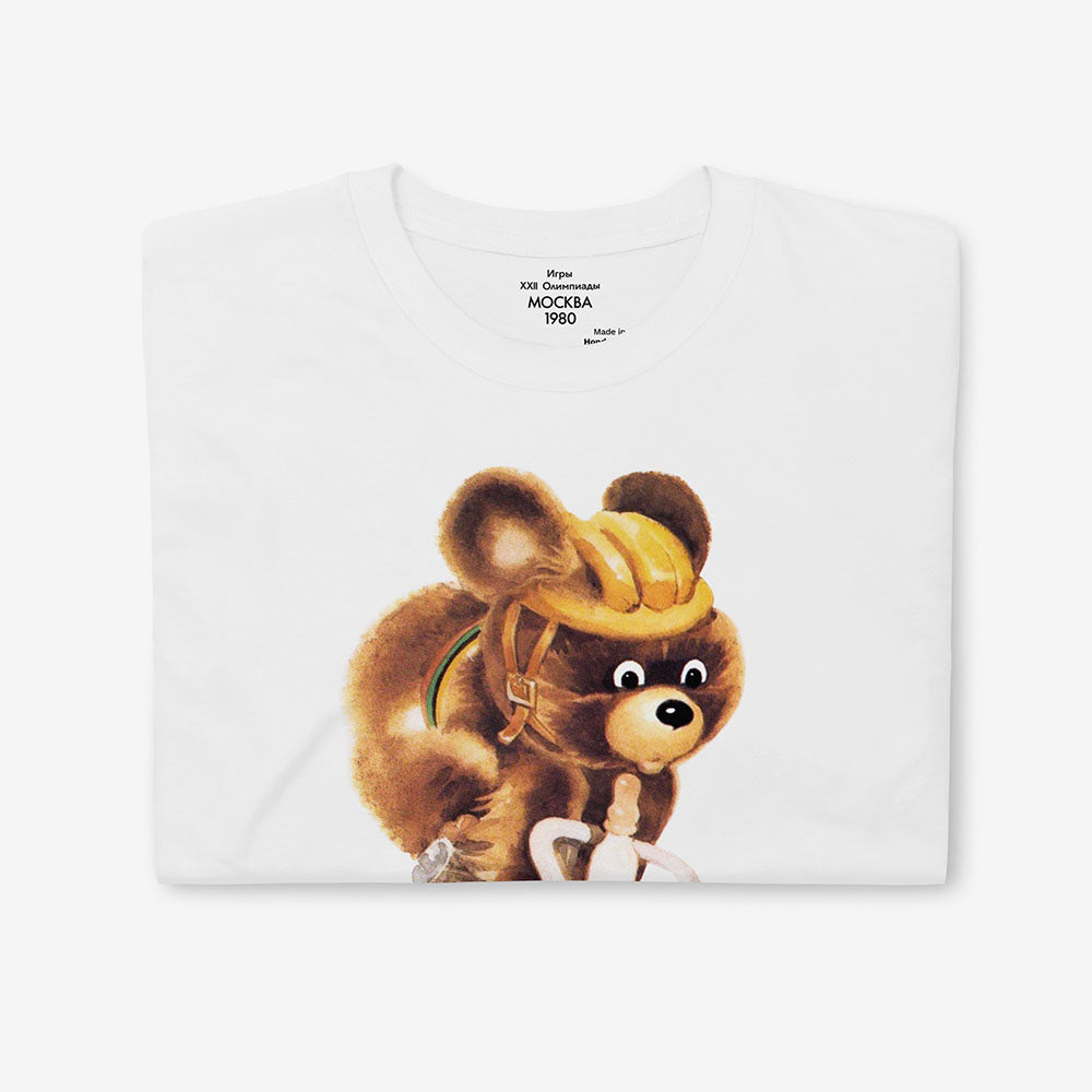White unisex T-shirt with Misha the Bear cycling, rare Moscow 1980 Olympic mascot illustration.