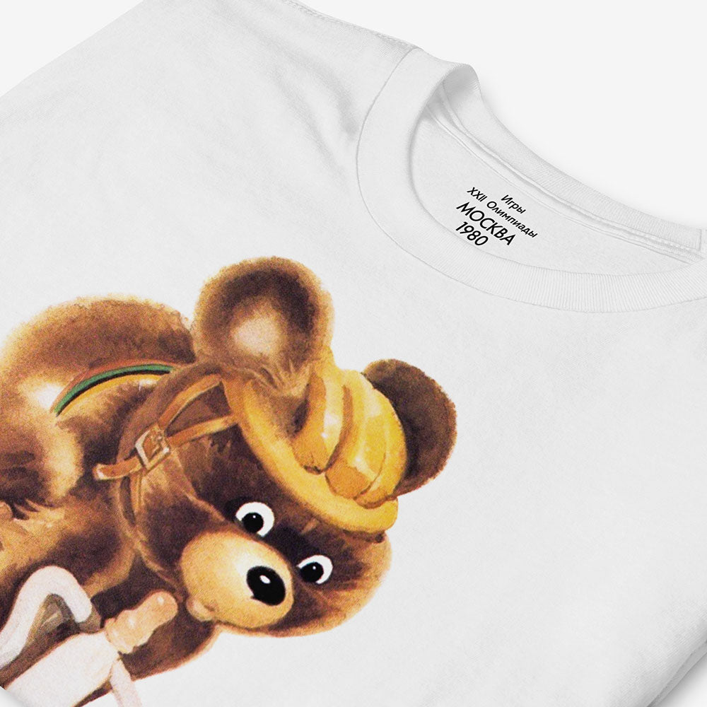 White unisex T-shirt with Misha the Bear cycling, rare Moscow 1980 Olympic mascot illustration.