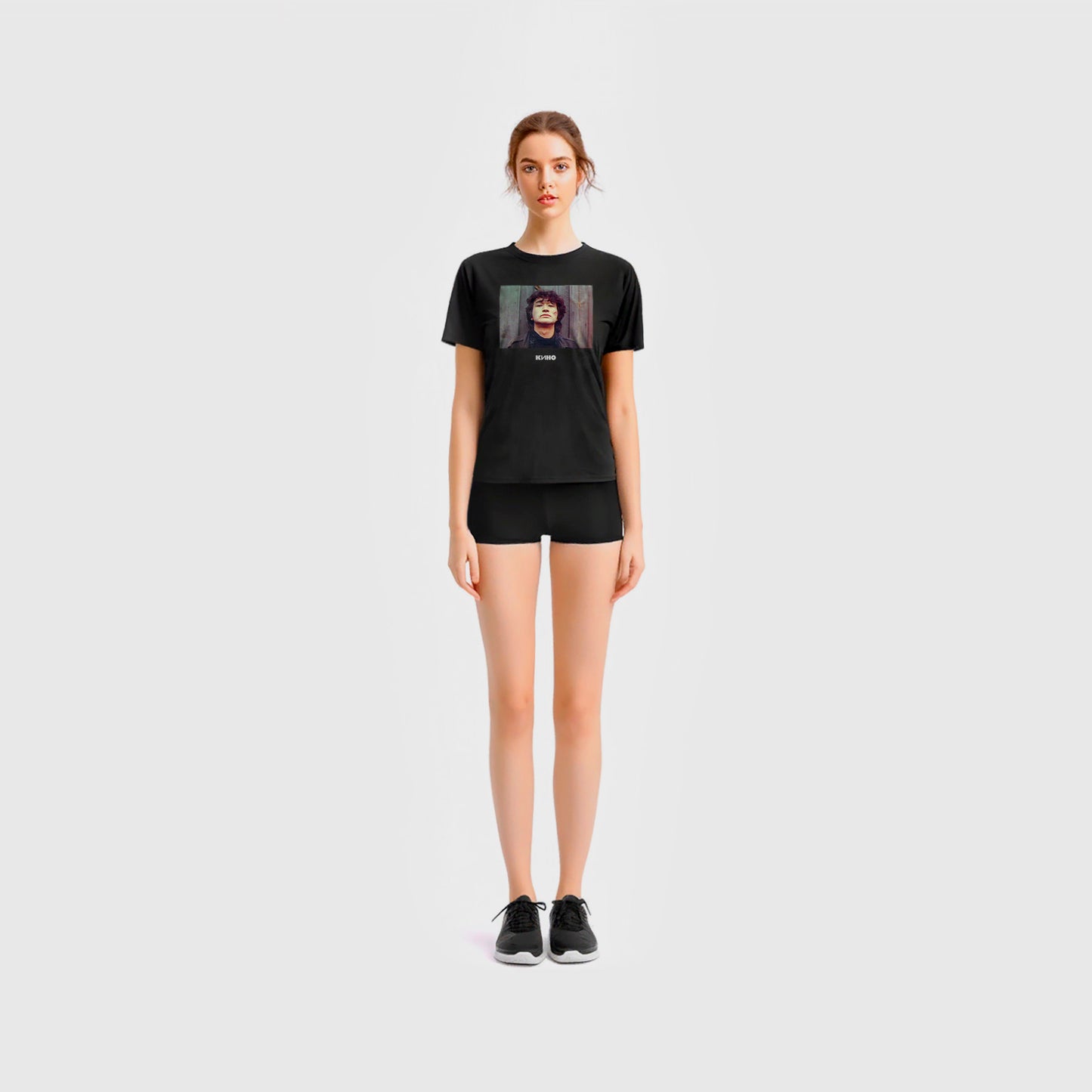 Cute young girl in short shorts wearing black unisex T-shirt with Viktor Tsoi photo and Gruppa KINO logo